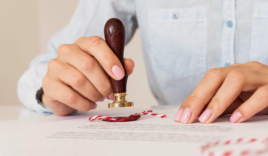 person-using-wax-seal-blurred-certificate (1)